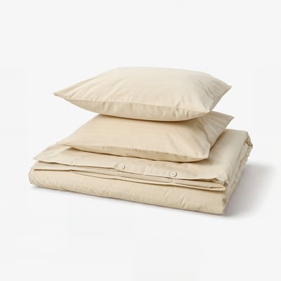 A folded beige DOFTAKLEJA duvet cover set with a chequered design, made of 100% cotton.