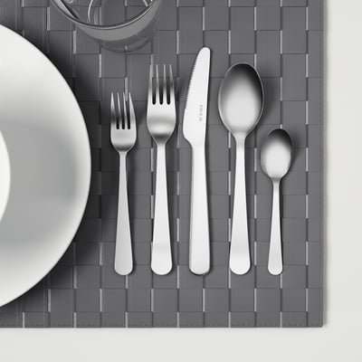 Stainless steel cutlery set on gray placemat.