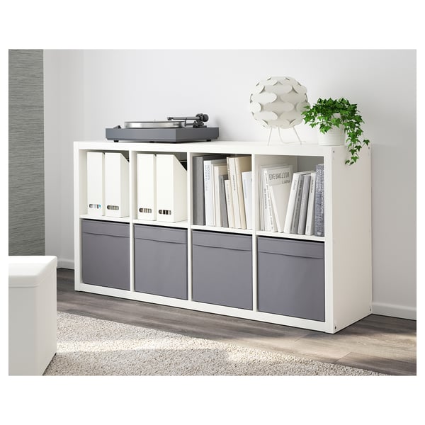 White kallax shelf with grey DRÖNA storage boxes, used for books and a record player.