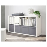 White kallax shelf with grey DRÖNA storage boxes, used for books and a record player.