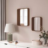 Two wall DVÄRGSYREN mirrors in walnut above white dressing table with lamp, brush, vase.