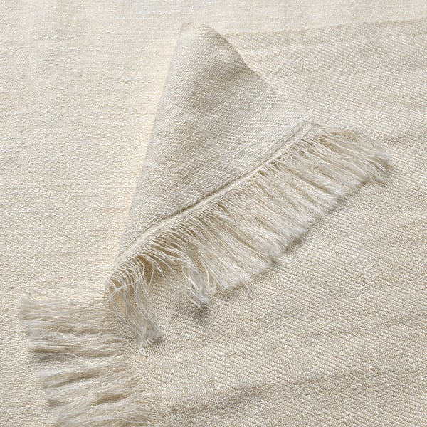 Soft, off-white throw with delicate fringes, showcasing high-quality linen-cotton blend texture.