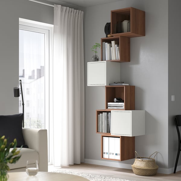 Modern living room with minimalist furniture: EKET shelves, beige sofa, floor lamp, and basket.