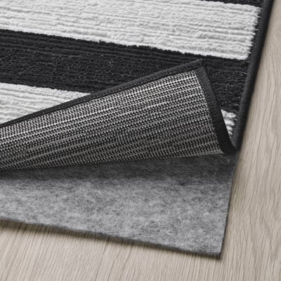 A black and white striped rug named ELSYSTEM, featuring a woven design with a soft, low pile, ideal for bedrooms or hallways.