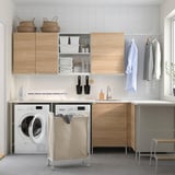 Modern laundry room with ENHET cabinets, sink, washer, and organized storage.