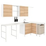 Modern l-shaped kitchen island, white & wood tone, stainless steel sink, black containers.