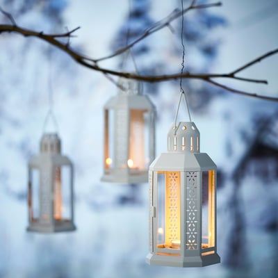 White octagonal ENRUM lantern with cutouts, steel & glass, warm glow, indoor/outdoor.
