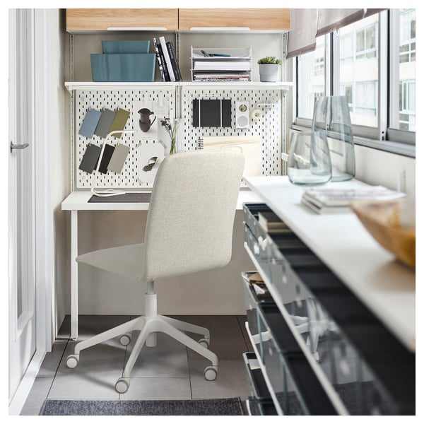 Home office setup with white ERFJÄLLET chair, gray fabric, adjustable height, padded, next to pegboard desk with organizers and books.