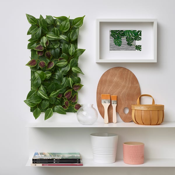 Wall-mounted FEJKA green plant panel with purple flowers, adding nature to decor. Eco-friendly, made from recycled plastic.