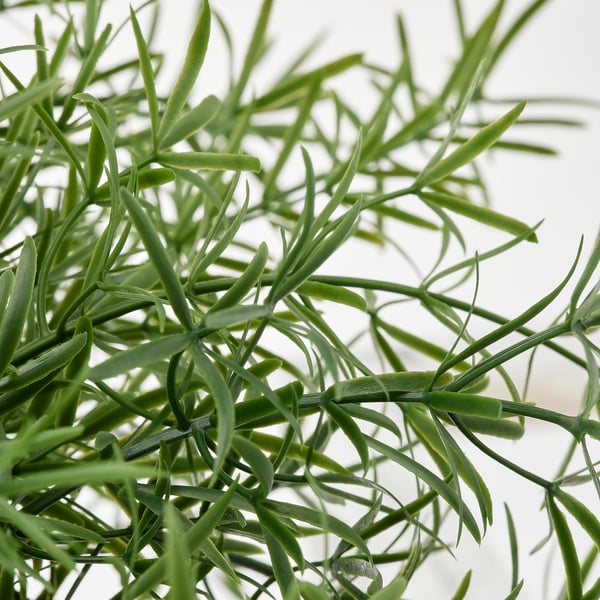 Artificial plant with vivid green leaves, closely packed, resembling natural foliage.