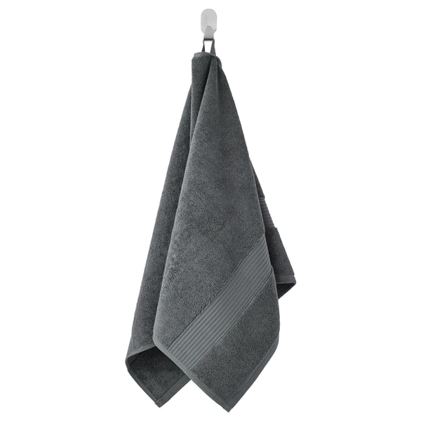 A hanging dark gray FREDRIKSJÖN towel, made of soft cotton, with a textured surface and a decorative woven border.