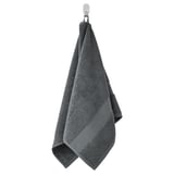 A hanging dark gray FREDRIKSJÖN towel, made of soft cotton, with a textured surface and a decorative woven border.