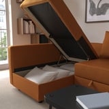 A versatile sofa bed with storage open, showing pillows and books.