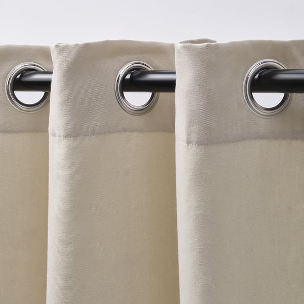 Beige curtains with eyelets for easy sliding, offering privacy while dimming daylight.