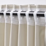 Close-up of beige curtains with rod pocket and pleats.
