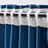 Curtains with white rod pockets, dark blue fabric, pleated for hanging.