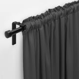 Black curtain rod holding dark grey curtains, with gathered top and wall-mounted bracket.