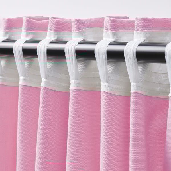 Pink curtains hang with white hooks on a metal rod, allowing light while providing privacy.