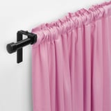 Pink curtains hang on black rod, gather at top, darken light, provide privacy.