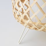 Handwoven bamboo pendant lamp, artfully crafted with intricate lattice pattern, casting warm light.