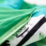 A green childrens bedding set with a zipper to secure the duvet in place. The fitted sheet has elastic edges for safety.