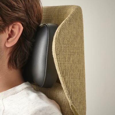 Head wearing black headphones resting on a green chair.