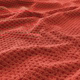Red cotton towel close-up. Soft, textured terrycloth. Fluffy, inviting feel.