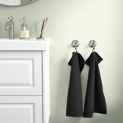 Two towels hang on hooks beside a white sink cabinet.