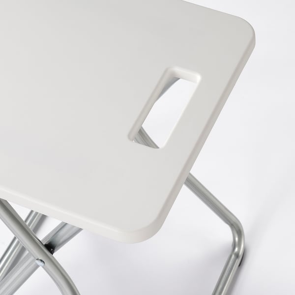 Foldable white stool with metal frame, designed for easy storage and wall-mounting.