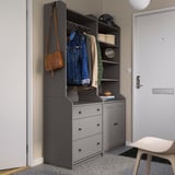 Modern entryway setup with gray HAUGA wardrobes, hanging jackets, and bags.