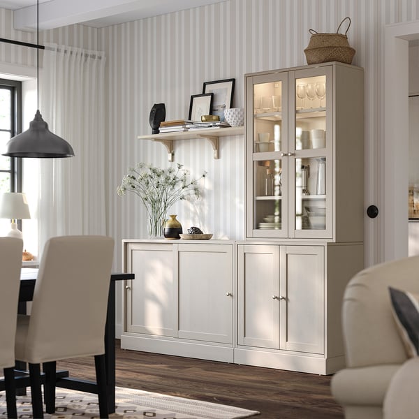 HAVSTA white sideboard with glass cabinet, striped wallpaper, beige chairs, wooden floor, decor.