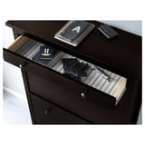 Dark wooden cabinet with open drawer showing gloves, notebooks, and wallet.