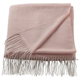 Light pink HOLMVI throw blanket, soft, rectangular with fringe edges, made from recycled polyester.