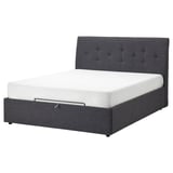 Dark gray upholstered bed with tufted headboard and white mattress.