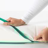 Person is opening a green child-safe zipper on a soft mattress segment.