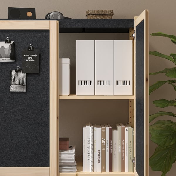 Bookshelf with felted doors and adjustable shelves stores books and boxes.
