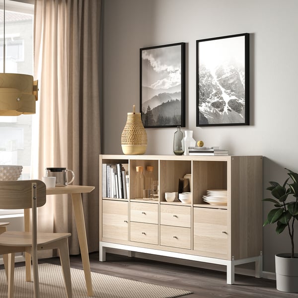 Modern living space with KALLAX shelf, honeycomb finish, bowls, books, vases, wicker basket, wooden furniture.