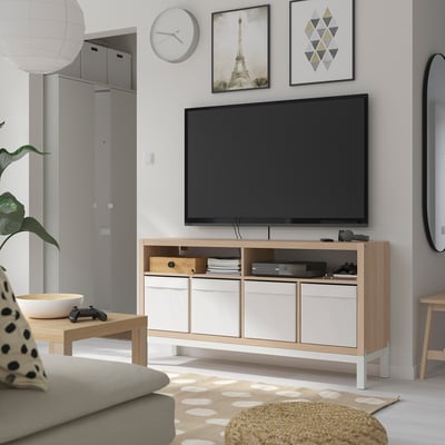 Minimalist tv room with KALLAX tv bench, flat-screen tv, gaming accessories, books, gray sofa, rug, wall art, clock, coffee table, and mirror.
