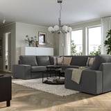 Modern living room with grey KIVIK sofa, coffee table, and pendant light. Large windows let in natural light, creating a cozy atmosphere.