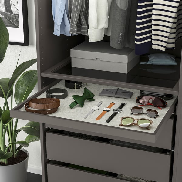 A wardrobe organizer with pull-out tray displaying accessories and clothes, ensuring easy access and visibility.