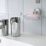 Bathroom organizer with toothbrush holder and soap dish; suction cups attach to tiles.