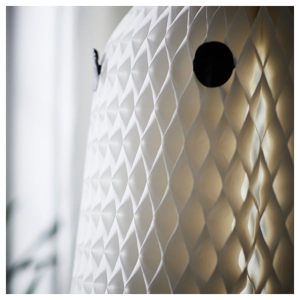 Ghostly lantern with patterned design, illuminated warmly. Textured, diamond-shaped cutouts cast intricate shadows.