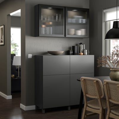 Modern kitchen LAPPVIKEN grey cabinets with sleek, simple design. Cabinets have glass doors and wooden chairs nearby.