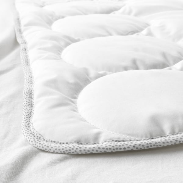 Close-up of a cozy, high-quality baby duvet. Soft, quilted fabric with a detailed, textured edge.