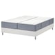 White bed with blue-gray mattress, split in two, on white base with legs.