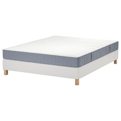 White LYNGÖR bed base with blue-gray vesteröy mattress. Square, wooden legs. Modern, minimalist design.