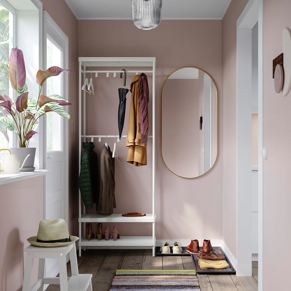 Cozy entryway with MACKAPÄR white coat rack, round mirror, and multicolored striped rug.