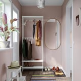 Cozy entryway with MACKAPÄR white coat rack, round mirror, and multicolored striped rug.