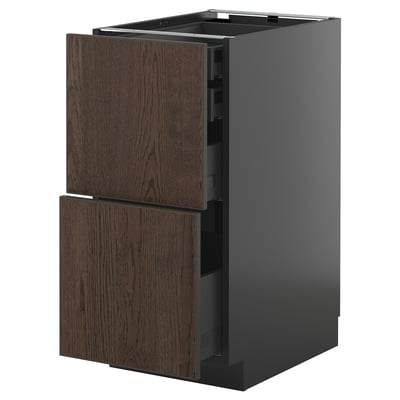 An open METOD kitchen cabinet with dark brown sinarp oak veneer drawers. The cabinet has a sleek, modern design with a smooth gray finish.