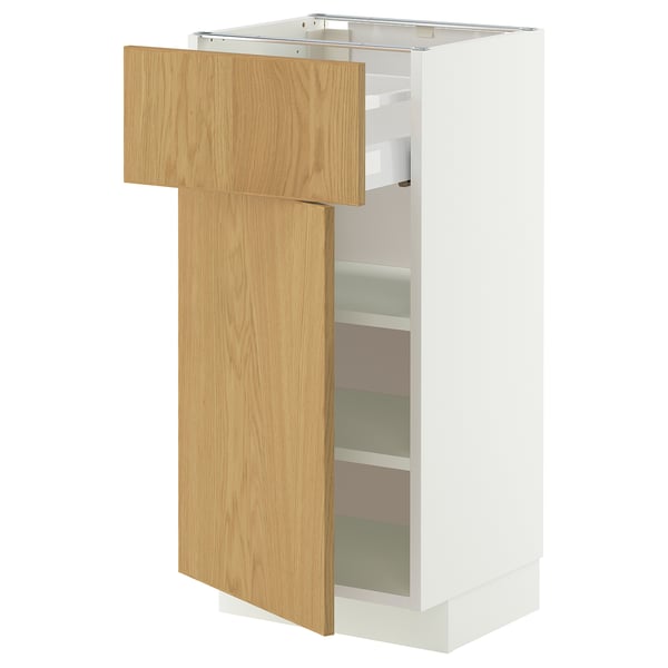 A white METOD storage cabinet with an oak veneer door slightly ajar, revealing adjustable shelves inside.